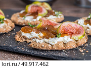 Canape or crostini with multigrain  crispread with cream cheese and fig jam on a slate board. Delicious appetizer ideal as an aperitif. Стоковое фото, агентство Ingram Publishing / Фотобанк Лори