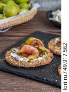 Canape or crostini with multigrain  crispread with cream cheese and fig jam on a slate board. Delicious appetizer ideal as an aperitif. Стоковое фото, агентство Ingram Publishing / Фотобанк Лори
