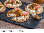 Canape or crostini with multigrain  crispread with cream cheese and fig jam on a slate board. Delicious appetizer ideal as an aperitif. Стоковое фото, агентство Ingram Publishing / Фотобанк Лори