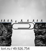Office solution concept as people crossing a bridge created by a giant paper clip or paperclip as a business worker success metaphor. Стоковое фото, агентство Ingram Publishing / Фотобанк Лори