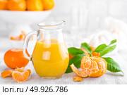 Tangerines, peeled tangerines and tangerine juice in glass. Mandarine juice. Стоковое фото, агентство Ingram Publishing / Фотобанк Лори