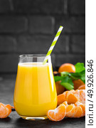 Tangerines, peeled tangerines and tangerine juice in glass. Mandarine juice and fresh fruits with leaves. Стоковое фото, агентство Ingram Publishing / Фотобанк Лори