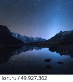 Starry night in Nepal. Amazing night scene with mountains and lake. Landscape with high rocks with snowy peak and sky with stars reflected in water in Nepal. Travel in  Himalayas. Space background. Стоковое фото, агентство Ingram Publishing / Фотобанк Лори