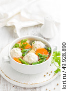 Fresh chicken soup with vegetables and meatballs in a bowl on white background. Top view. Стоковое фото, агентство Ingram Publishing / Фотобанк Лори