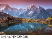 Beautiful landscape with high mountains with snow covered peaks, sky reflected in lake. Mountain valley with reflection in water in sunrise. Nepal. Amazing scene with Himalayan mountains. Nature. Mountain valley with reflection in water in sunrise. Стоковое фото, агентство Ingram Publishing / Фотобанк Лори