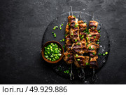 Grilled meat skewers, shish kebab on black background, top view. Стоковое фото, агентство Ingram Publishing / Фотобанк Лори