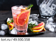 Grapefruit and fresh rosemary gin cocktail with juice, cold summer citrus refreshing drink or beverage with ice. Стоковое фото, агентство Ingram Publishing / Фотобанк Лори