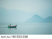 SONGKLA, THAILAND -MARCH 13 : Unidentified villagers in a boat do fishing in the waters on MARCH 3, 2016 in Songkla, Thailand. Fishing is a major activity of people living in the water region. Редакционное фото, агентство Ingram Publishing / Фотобанк Лори