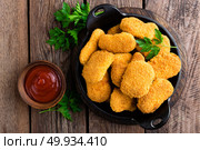 Nuggets. Chicken nuggets with ketchup on wooden table. Fast food. Стоковое фото, агентство Ingram Publishing / Фотобанк Лори