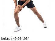 Young sport man with strong athletic legs holding knee with his hands in pain after suffering ligament injury  isolated on white.. Young sport man with strong athletic legs holding knee with his . Стоковое фото, агентство Ingram Publishing / Фотобанк Лори