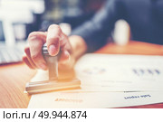 Close-up hand stamping of businessman for signing approval on documents , business concept. Стоковое фото, агентство Ingram Publishing / Фотобанк Лори