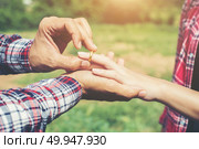 Young hipster couple wearing engagement ring in nature,Sweet and. Young hipster couple wearing engagement ring in nature,Sweet and a good time in life. Happy and very grateful. Стоковое фото, агентство Ingram Publishing / Фотобанк Лори