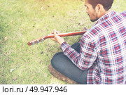 Young hipster man practiced guitar in the park,happy and enjoy p. Young hipster man practiced guitar in the park,happy and enjoy playing guitar. Стоковое фото, агентство Ingram Publishing / Фотобанк Лори