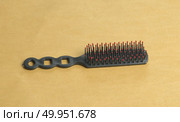 Black comb closeup on brown vintage background. Стоковое фото, агентство Ingram Publishing / Фотобанк Лори