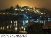 Mon Bridge at the night time. Mon Bridge is the largest wooden bridge across the river Sanglkla. It is situated at Sangklaburi, Kanchanaburi near by border with Myanmar. Стоковое фото, агентство Ingram Publishing / Фотобанк Лори