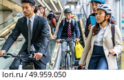 Group of individuals descending escalator while riding bicycles. Unconventional use of escalator with cyclists. Urban setting, dynamic movement. Стоковое AI-изображение, AI-художник Данила Большаков / Фотобанк Лори