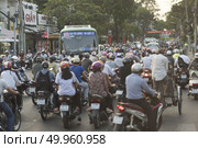 HO CHI MINH CITY, VIETNAM - FEBRUARY 1, 2016: traffic jam with a congestion of scooters and people with colorful helmets. There are approximately 340,000 cars and 3,5 million motorcycles in the city. Редакционное фото, агентство Ingram Publishing / Фотобанк Лори