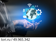 Businessman touching on technology smartphone with business glob. Businessman touching on technology smartphone with business global icons on screen. Business technology concept. Стоковое фото, агентство Ingram Publishing / Фотобанк Лори
