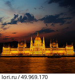 Facade of illuminated Budapest Parliament under cloudy sky, Hungary. Стоковое фото, агентство Ingram Publishing / Фотобанк Лори