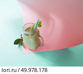 Vegetarian healthy smoothies from green vegetables with green leaves and plastic straw in a glass bowl on duotone pink green paper background. Pink paper twisted in any shape.. Green smoothie from green organic vegetables with asparagus and celery in a glass bowl on duotone pink green paper background. Стоковое фото, агентство Ingram Publishing / Фотобанк Лори