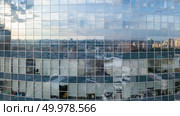 The reflection of cityscape in the windows of modern business center building in the summer day, at sunset.. Modern building with reflection of blue sky and clouds. Aerial shot from the drone. Стоковое фото, агентство Ingram Publishing / Фотобанк Лори