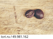 coffee beans on wooden background, arabica coffee, vintage filter image. Стоковое фото, агентство Ingram Publishing / Фотобанк Лори
