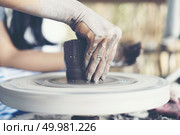 The woman’s hands close up, the masterful studio of ceramics works with clay on a potter’s wheel. Стоковое фото, агентство Ingram Publishing / Фотобанк Лори