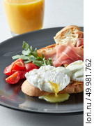 Eggs Benedict with ham and tomato on toast and orange juice. Eggs Benedict with ham and tomato. Стоковое фото, агентство Ingram Publishing / Фотобанк Лори