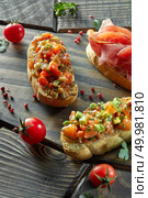 assorted Italian appetizer bruschetta on a dark wooden background. assorted Italian appetizer bruschetta. Стоковое фото, агентство Ingram Publishing / Фотобанк Лори