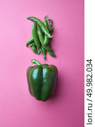 Organic green peppers and peas pods on a pink background with copy space. Flat lay. Creative food layout. Green pea pods and whole green pepper on a pink background. Food Concept. Top view. Стоковое фото, агентство Ingram Publishing / Фотобанк Лори
