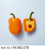 Fresh organic sweet yellow pepper and its half isolated on a gray background, top view. Concept organic food or raw food diet. halves of yellow sweet pepper on a gray background. Стоковое фото, агентство Ingram Publishing / Фотобанк Лори