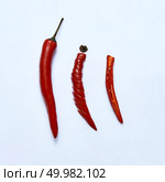 Red chili pepper cut into slices as a version of slicing for cooking on a gray background, top view. sliced red chili or chilli cayenne pepper on a gray background, top view. Стоковое фото, агентство Ingram Publishing / Фотобанк Лори