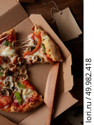 Top view of pieces of cheese pizza in paper box over wooden table. Pieces of fresh pizza. Стоковое фото, агентство Ingram Publishing / Фотобанк Лори