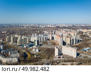 Panorama aerial view of the city on a sunny spring day. Modern high-rise buildings and a small church. Drone photography. Panorama view of the city in spring on a sunny day. Редакционное фото, агентство Ingram Publishing / Фотобанк Лори
