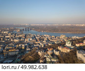 Aerial view from the drone, bird’s eye view to the Vozdvizhenka, Podolsky bridge, St. Andrew’s Church, National Museum of Ukrainian History, Andreevsky descent.. A bird’s eye view, aerial view shooting from drone of the Podol district, oldest historical center of Kiev, the Dnieper River and the left bank of Dnieper in the city of Kiev, Ukraine. Стоковое фото, агентство Ingram Publishing / Фотобанк Лори