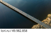 Top view on the Dnieper River and the North Bridge with passing cars on a spring day Kiev, Ukraine. Drone photography. Kiev, Ukraine view from above on the North Bridge with passing cars through the Dnieper River, photo from the drone. Стоковое фото, агентство Ingram Publishing / Фотобанк Лори