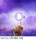Icons bitcoin, ripple, ethereum and cryptocurrency graph on virtual screen on an ultra violet background of a modern city. The hand touches the bitcoin icon. Blockchain Business, Finance and technology concept.. Icons bitcoin ripple, ethereum on an ultra purple background of the city. The hand touches the bitcoin icon. Стоковое фото, агентство Ingram Publishing / Фотобанк Лори