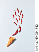 Red hot chili peppers in sugar waffle cones on gray background, flat lay. hot chili peppers in wafer cones on gray background, top view. Стоковое фото, агентство Ingram Publishing / Фотобанк Лори