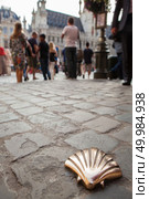 Saint James way shell golden metal on streets soil stone floor with a crowd of people on the main square in Brussels, Belgium. St James shell in Brussels. Стоковое фото, агентство Ingram Publishing / Фотобанк Лори
