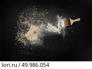 Sprinkled flour with brush for cooking over black background. Background after cooking fresh and delicious bread of different kinds.. Sprinkled flour over background. Стоковое фото, агентство Ingram Publishing / Фотобанк Лори