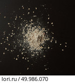 Bread crumbs with flour represented in middle of table over black background. Crumbs and flour after baking and cooking fresh bread.. Sprinkled flour over background. Стоковое фото, агентство Ingram Publishing / Фотобанк Лори