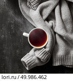 grey cozy knitted sweater with to cup of tea on a wooden black table. knitted sweater with to cup of tea. Стоковое фото, агентство Ingram Publishing / Фотобанк Лори