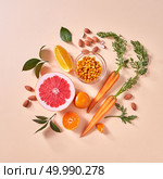 Healthy vegetarian food - orange organic vegetables and fruits on a paper background. Top view. Concept of organic natural vegetarian food.. Natural organic citrus fruits, carrots, sea buckthorn berries - ingredients for making homemade detox smoothie on yellow paper background. Стоковое фото, агентство Ingram Publishing / Фотобанк Лори