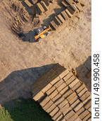Aerial view from drone agricultural machine collecting bales of hay on a field. Farm industry. Top view. Aerial view of a tractor folding bales of hay in a field on a sunny autumn day. Photo from drone. Top view. Стоковое фото, агентство Ingram Publishing / Фотобанк Лори