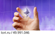 Business men holding a transparent screen with an icon of etereum on the ultraviolet background of the city. Business, Blockchain technology.. Icon of etereum on a transparent digital screen on the ultraviolet background of the city. Стоковое фото, агентство Ingram Publishing / Фотобанк Лори