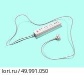 White extension cord on a green background. Concepts electricity,power. White Extension Cable on a Green Background. Стоковое фото, агентство Ingram Publishing / Фотобанк Лори