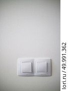 Double white lighting switchs on concrete wall, electrical power socket and plug switched with copy space. Electric two white lighting switchs on concrete wall. Стоковое фото, агентство Ingram Publishing / Фотобанк Лори