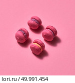 Fresh baked purple pink macaroon pastry cookies in pink background, top view. Sweets. Food background.. pink macaroons on pink background, homemade food. Стоковое фото, агентство Ingram Publishing / Фотобанк Лори
