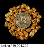 Circle from the mound of gold nuggets and from above Gold Bitcoin Coin. Bitcoin as desirable as digital gold concept. Bitcoin cryptocurrency.. Bitcoin on mound of gold nuggets on a black background, bitcoin cryptocurrency concept. Стоковое фото, агентство Ingram Publishing / Фотобанк Лори
