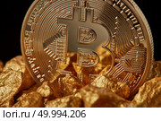 Closeup of gold nugget and Gold Bitcoin Coin on black background . Bitcoin as desirable as digital gold concept. Bitcoin cryptocurrency.. Closeup of gold nugget and Gold Bitcoin Coin on black background. Стоковое фото, агентство Ingram Publishing / Фотобанк Лори